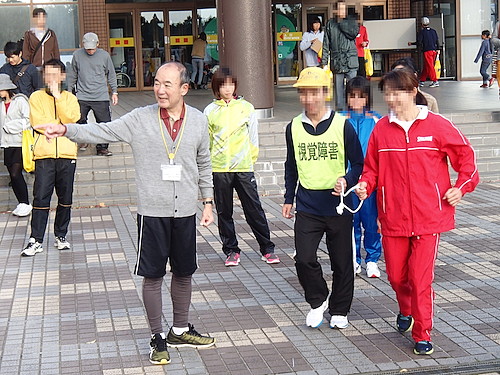 福知山マラソンの前日に行った伴走サポーター講習会で参加者と協力者が会場前の広場で実技を行っている風景です。